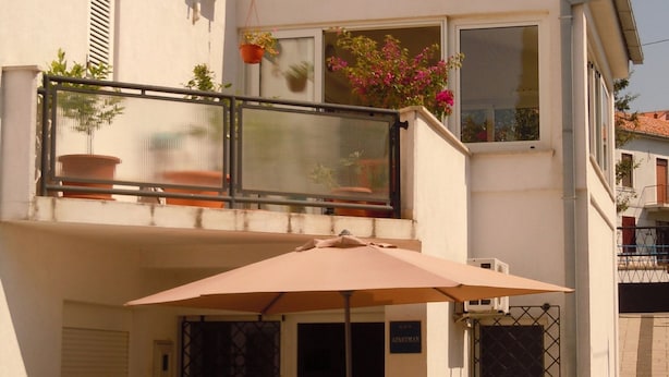 A balcony with potted plants, a hanging flower pot, and a sign reading "APARTMAN". - Charming and Cozy Apartment Crikvenica (Crikvenica)