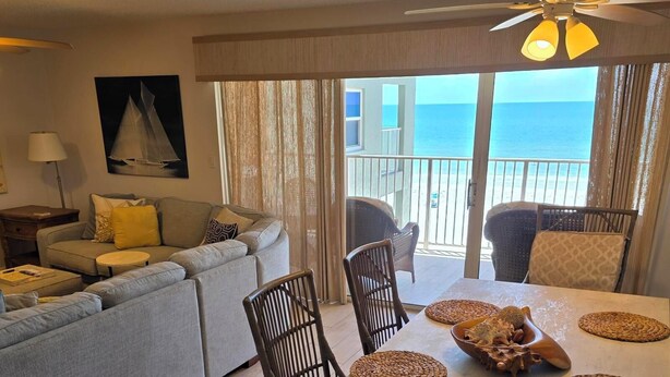 A living room with a sofa, chairs, and a dining table with placemats.