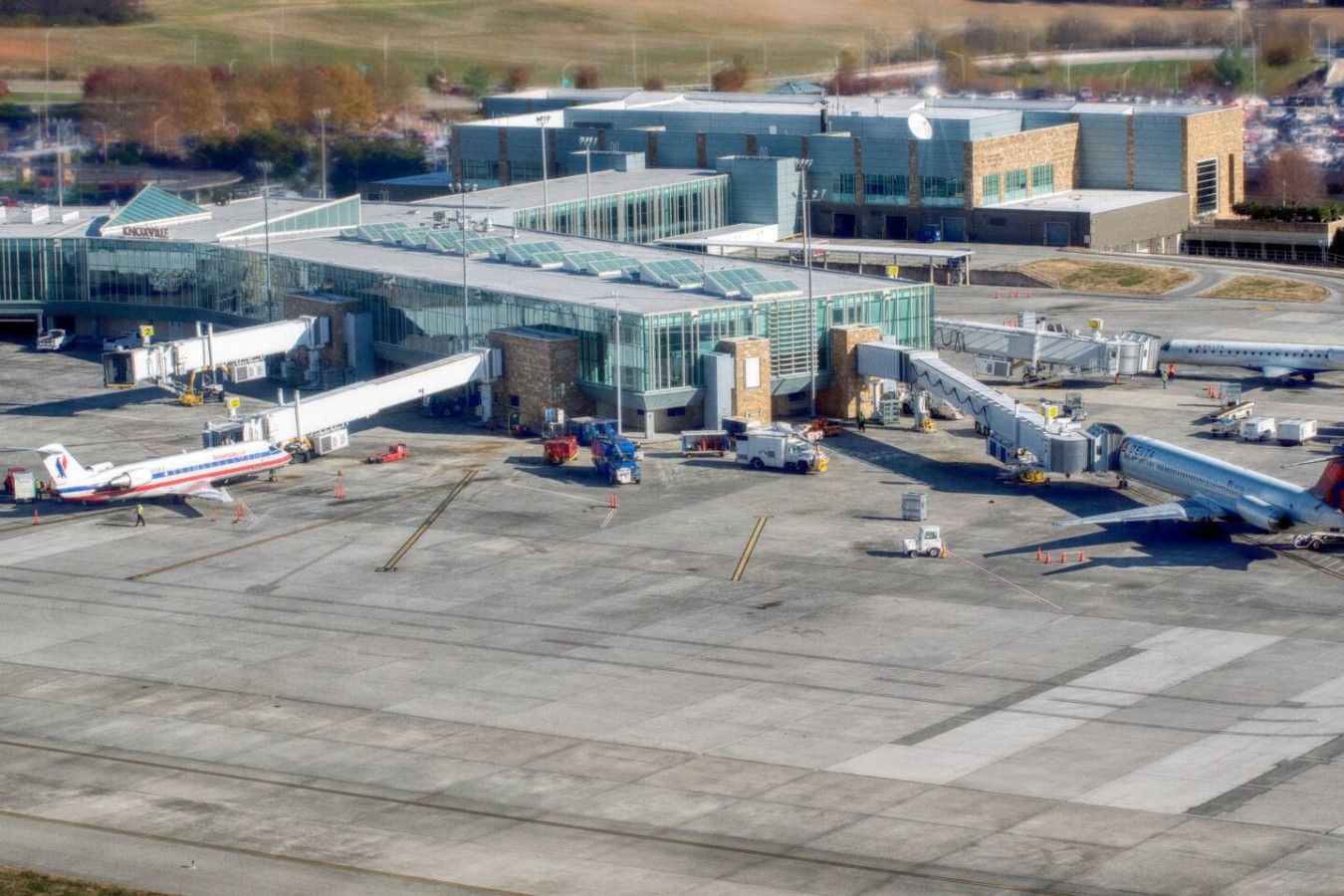 Ein Flughafenterminal mit Glasfassade, mehreren Flugsteige und abgestellten Flugzeugen.