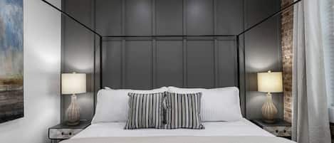 Un dormitorio con una cama grande, dos lámparas de noche y un cuadro en la pared.