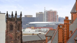 A historic building with a prominent tower and arched windows, a modern building labeled "Prudential Center" in the background, and a large stadium. - Exceptional 2BR ! Free Parking ! 30 Min to NYC ! (Newark)