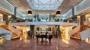 A spacious lobby with a grand piano, a central staircase, and a high ceiling with a geometric pattern. - Pickalbatros Hôtel Du Golf - Adults Friendly 16 Years Plus- All-Inclusive (Marrakech)