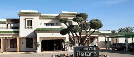 A building with a sign reading "Golf Club Rotana" in front.