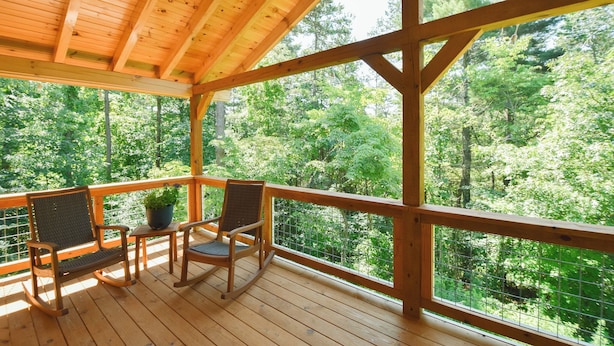 A wooden deck with two rocking chairs and a small table, overlooking a forested area. - Cabin, Hot Tub, Fire Pit, 4 miles to Downtown AVL (Asheville)