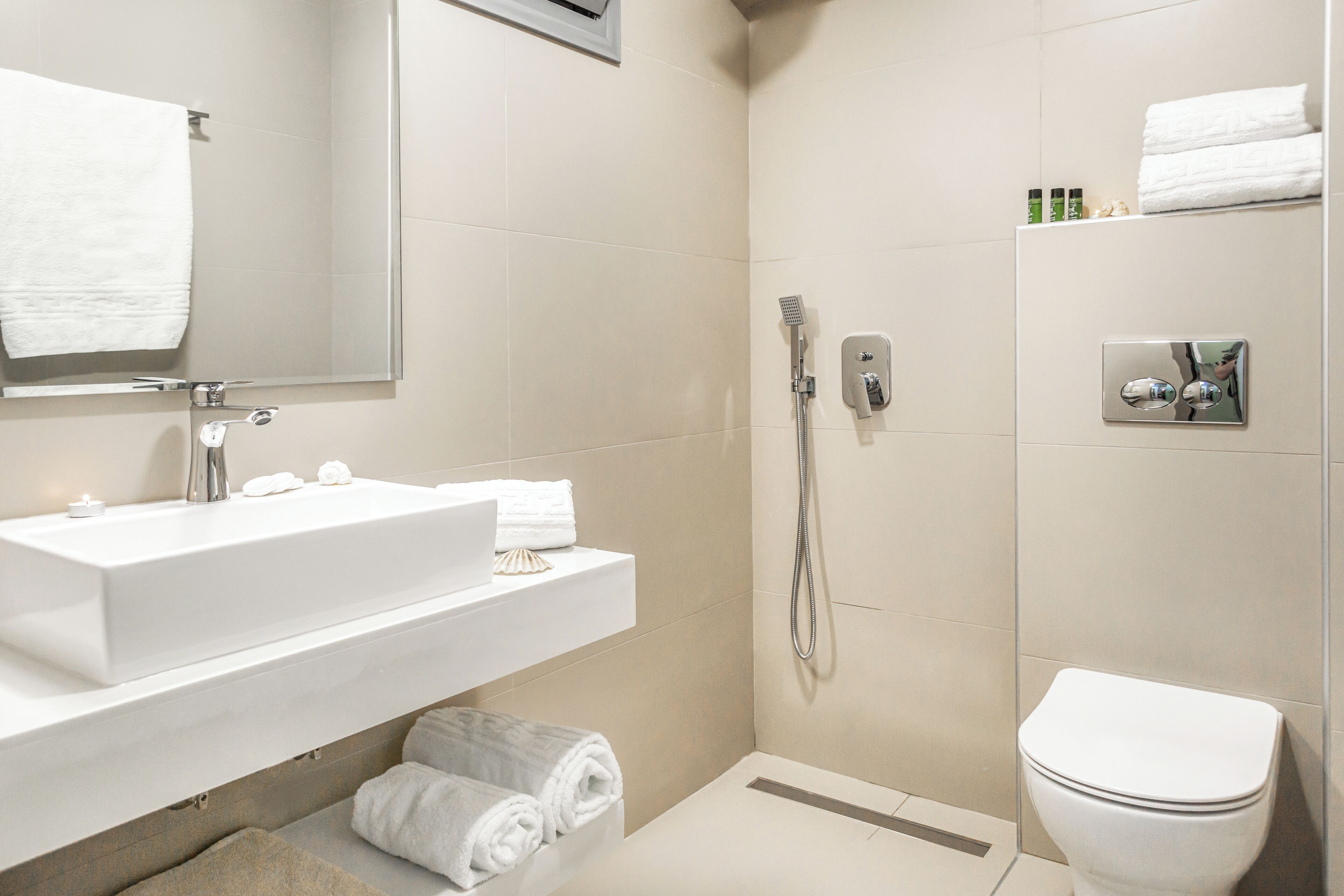 Een moderne badkamer met een wit wastafelmeubel, spiegel en toilet.