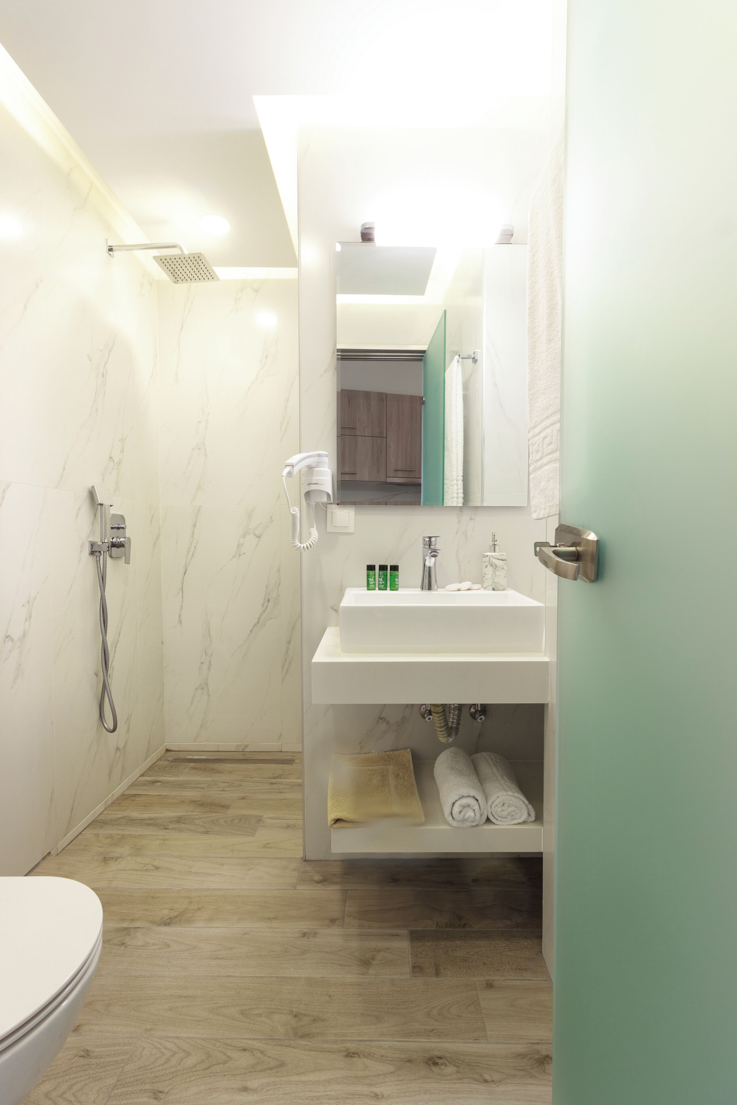 A modern bathroom with a shower, toilet, and sink.