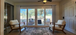 A room with a sliding glass door leading to a patio with outdoor furniture.