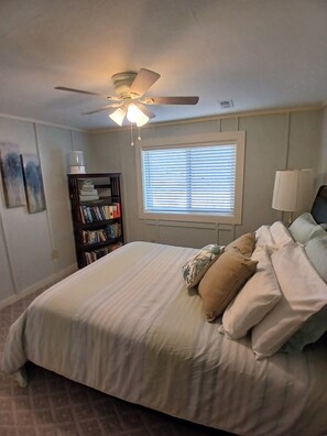 Relax in a spacious bedroom with a large bed, bookshelf, and reading nook.