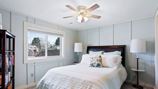 A bedroom with a large bed, a ceiling fan, a window with blinds, a bookshelf, and two bedside lamps. - Sunny Private Guest Suite, 30 min from Denver/Boulder, Kids and Pets welcome! (Broomfield)