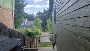 A narrow concrete pathway leading to a house with a green roof and a wooden fence. - Sunny Private Guest Suite, 30 min from Denver/Boulder, Kids and Pets welcome! (Broomfield)