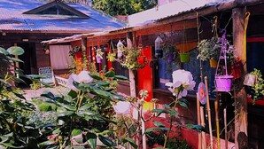 A rustic building with a corrugated metal roof and red doors. - hostel mi lugar (Mar del Plata)