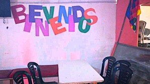 A room with a white table and four black chairs. A colorful mural with the text "BEYOND" is on the wall. - hostel mi lugar (Mar del Plata)
