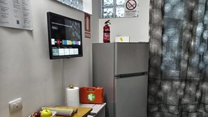 Una cocina compacta con una mesa de madera, un refrigerador y una ventana con vistas.