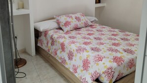 Un dormitorio pequeño con una cama, un estante y un aire acondicionado de pared.