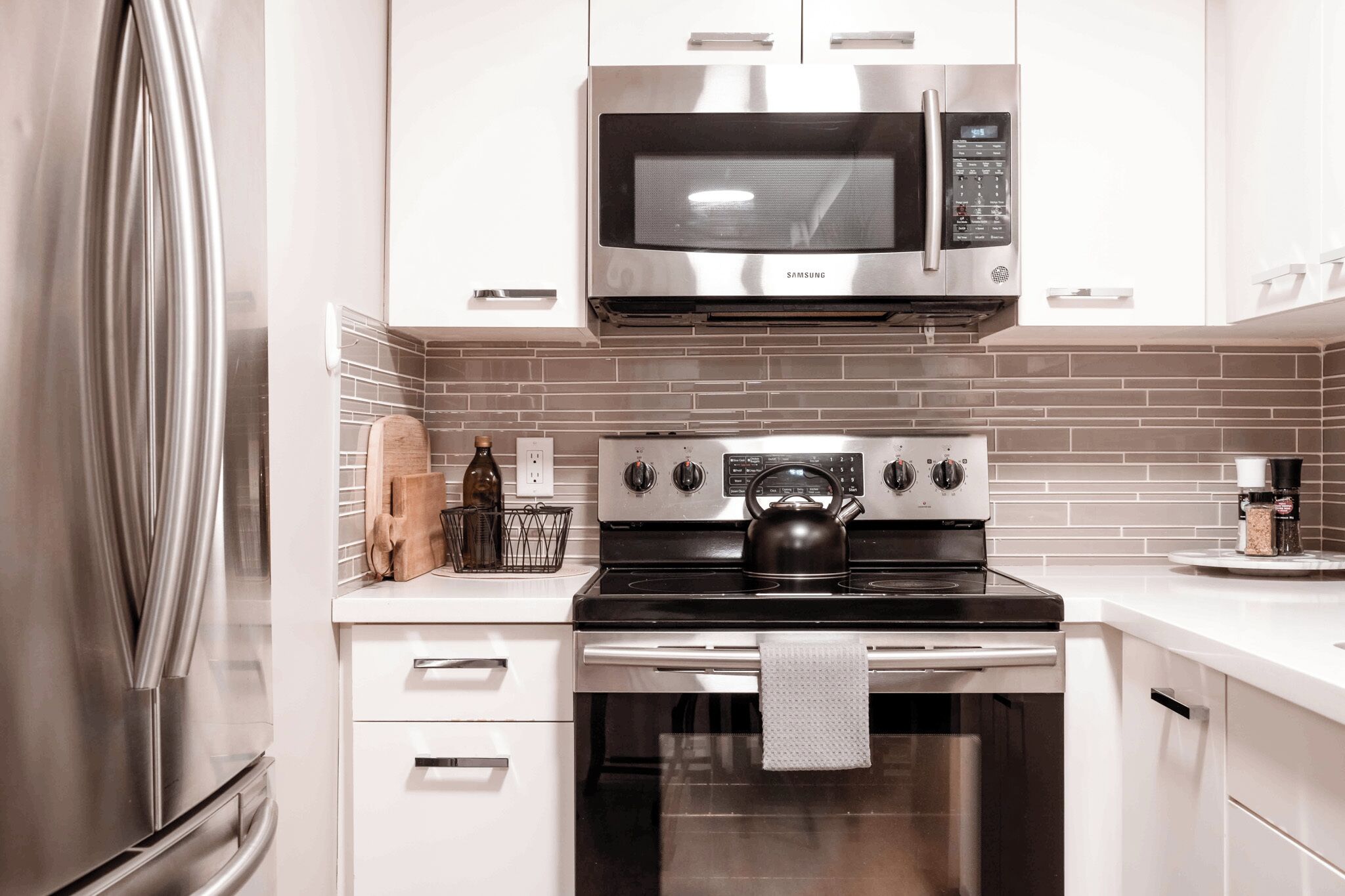 A modern kitchen with stainless steel appliances, including a microwave, oven, and refrigerator.