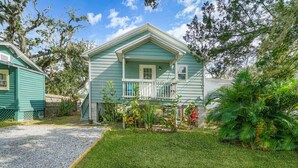 A two-story house with a front porch and a small garden. - Oak St Oasis - Minutes from Downtown and the beach! (Downtown St. Augustine)