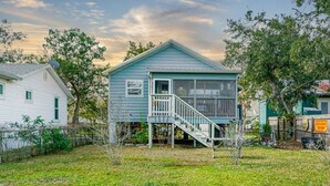 A small, single-story house with a porch and a staircase leading to a deck. - Oak St Oasis - Minutes from Downtown and the beach! (Downtown St. Augustine)