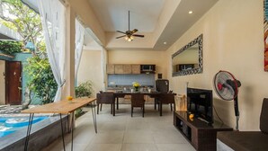A modern living room with a dining area, kitchen, and a pool. - Perenan Villa - Two Bedroom Villa, Sleeps 4 (Pererenan)