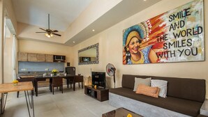 A modern living room with a sofa, coffee table, and dining area. - Perenan Villa - Two Bedroom Villa, Sleeps 4 (Pererenan)