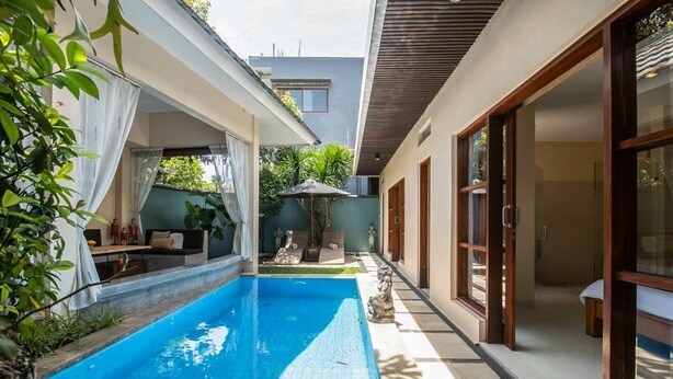 A swimming pool with a tiled deck, a covered seating area with a table and chairs, and a statue in the center. - Perenan Villa - Two Bedroom Villa, Sleeps 4 (Pererenan)