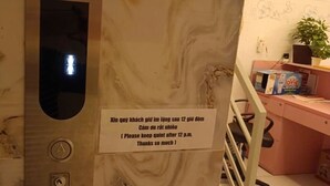 Ein Hotelzimmer mit Marmorwand, einem kleinen Fenster, einem Schreibtisch mit Computer, einem Stuhl und einer Topfpflanze.