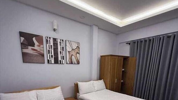 Ein Hotelzimmer mit zwei Betten, einem Kleiderschrank und einem Bild an der Wand.