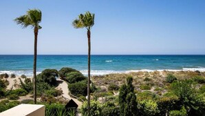 A coastal view with two palm trees, a sandy beach, and a clear blue sky. - Holiday Home Marbella Near Sand Beach (Marbella)