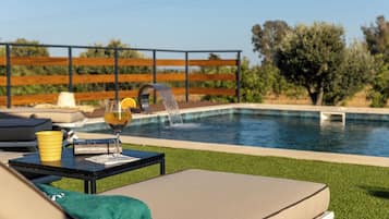 Relax by the serene pool surrounded by a lush lawn and a fence.