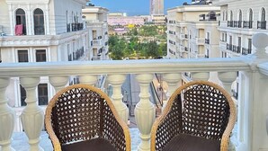 A balcony with wicker chairs and a view of a cityscape. - Tashkent city Bulevard 144 RNB estate (Tashkent)