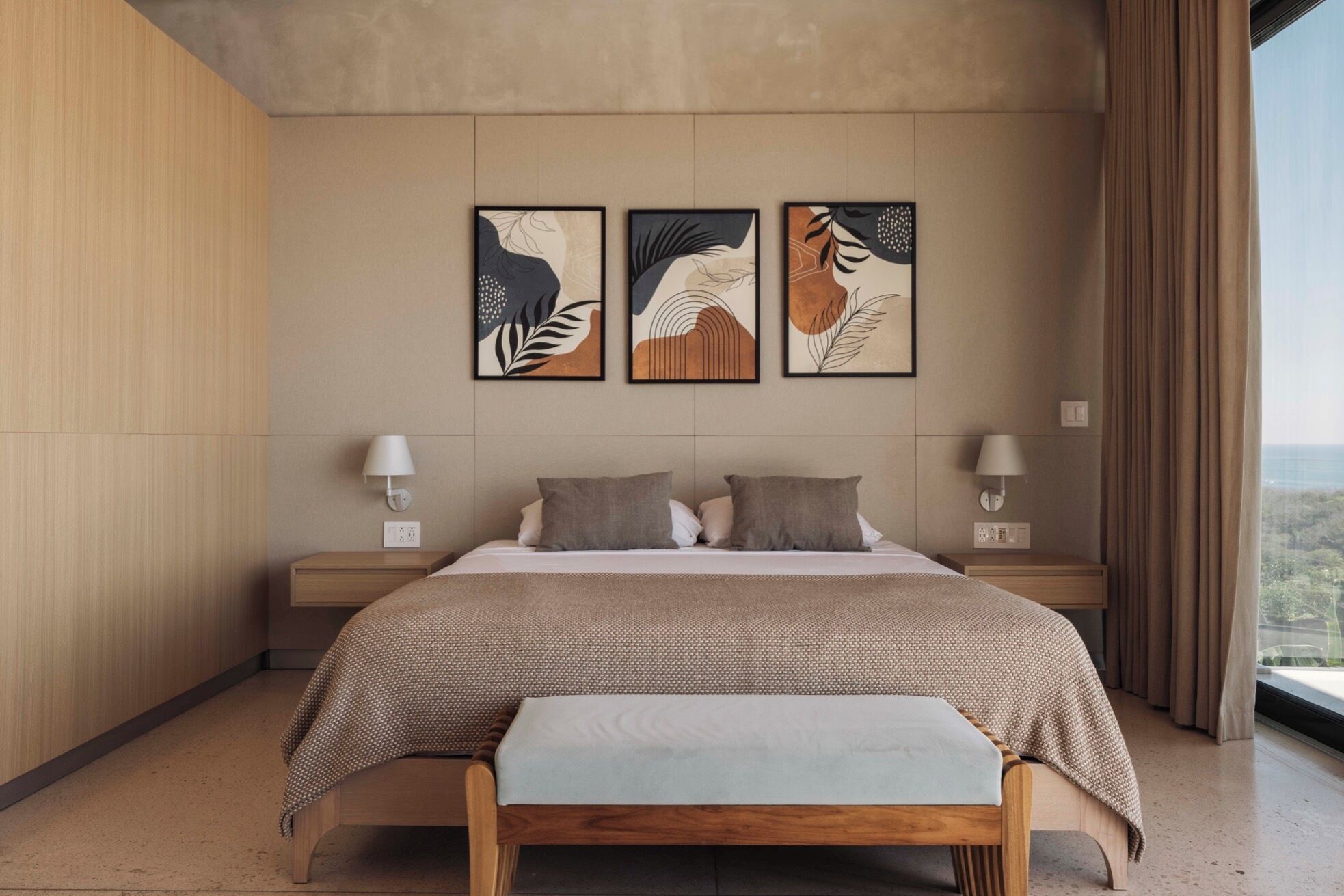 Een moderne slaapkamer met een groot bed, twee nachtkastjes en drie wanddecoraties.