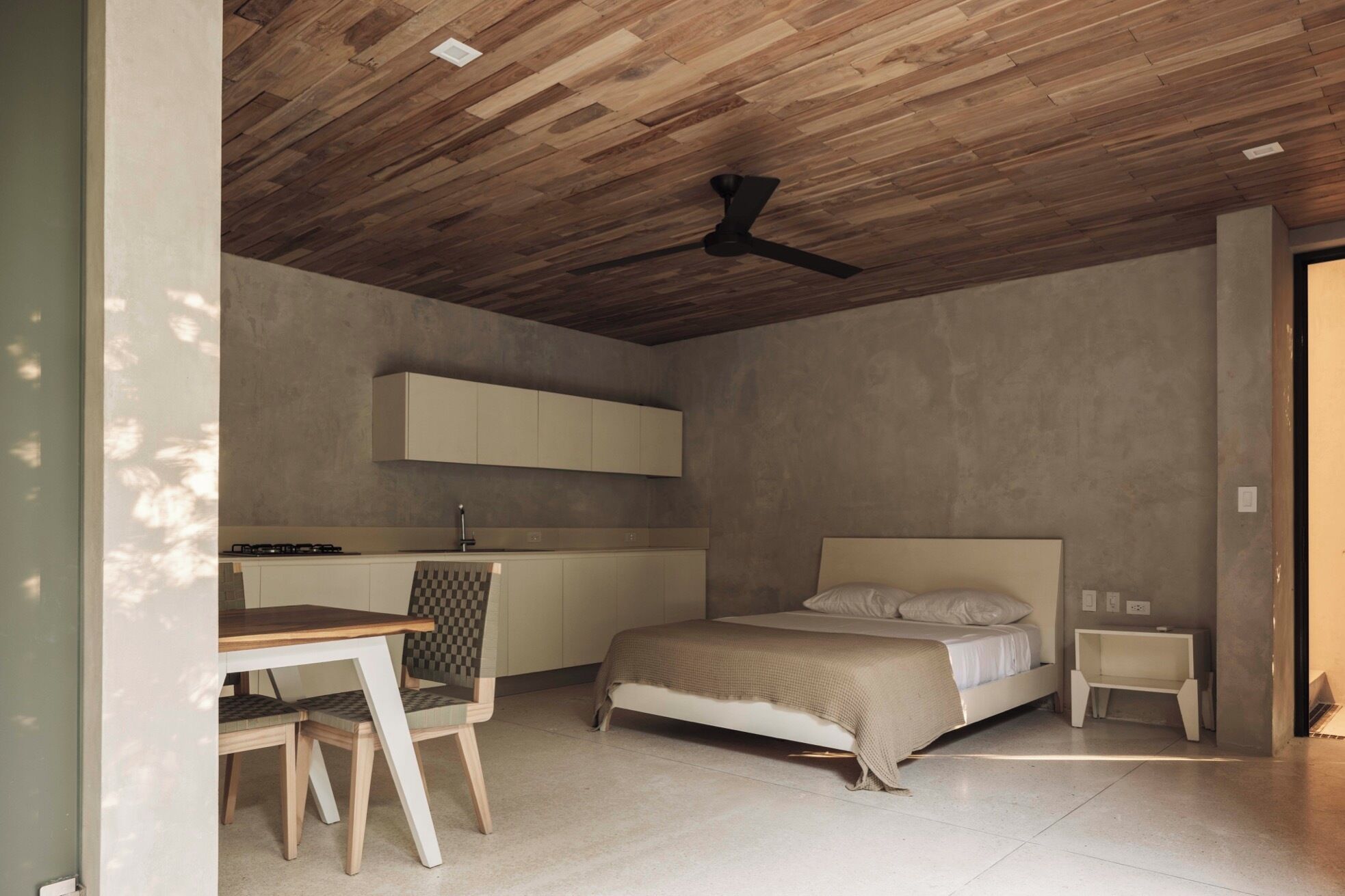 Ein Schlafzimmer mit Bett, Nachttisch und Schreibtisch mit Stuhl.