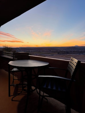Relax in this serene outdoor seating area overlooking a breathtaking view of a distant mountain.