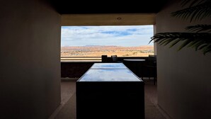 A room with a view of a desert landscape, a table, and chairs. - Spacious 2BR Condo with Secondary Suite on Wolf Creek Golf Course – Sleeps 8! (Mesquite)