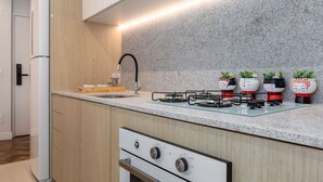 A modern kitchen with wooden cabinets, a granite countertop, a built-in oven, a gas stove, and a stainless steel sink.