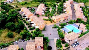 An aerial view of a residential area with multiple houses, a central courtyard, and a swimming pool. - Mini villa Saint Cyprien, swimming pool, 500m from the beach  (Lecci)