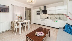 A modern kitchen with white cabinets, a built-in microwave, and a gas stove. - Piasek Apt - Top Location, Patio, Tram&Bus nearby - by Rentujemy (Kraków)