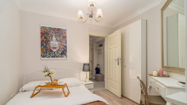 A hotel room with a bed, bedside table, lamp, and a painting on the wall. - Piasek Apt - Top Location, Patio, Tram&Bus nearby - by Rentujemy (Kraków)