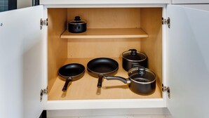 Un armario de cocina con estante interior de madera y exterior blanco.