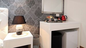 A compact room with a white desk, a small trash bin, a white radiator, and a wall-mounted air conditioner. - Zadar Luxury Rooms (Zadar)