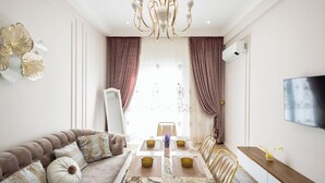 A modern living room with a marble dining table, a sofa, and a television mounted on the wall. - Amir Temur avenu 123  (Tashkent)