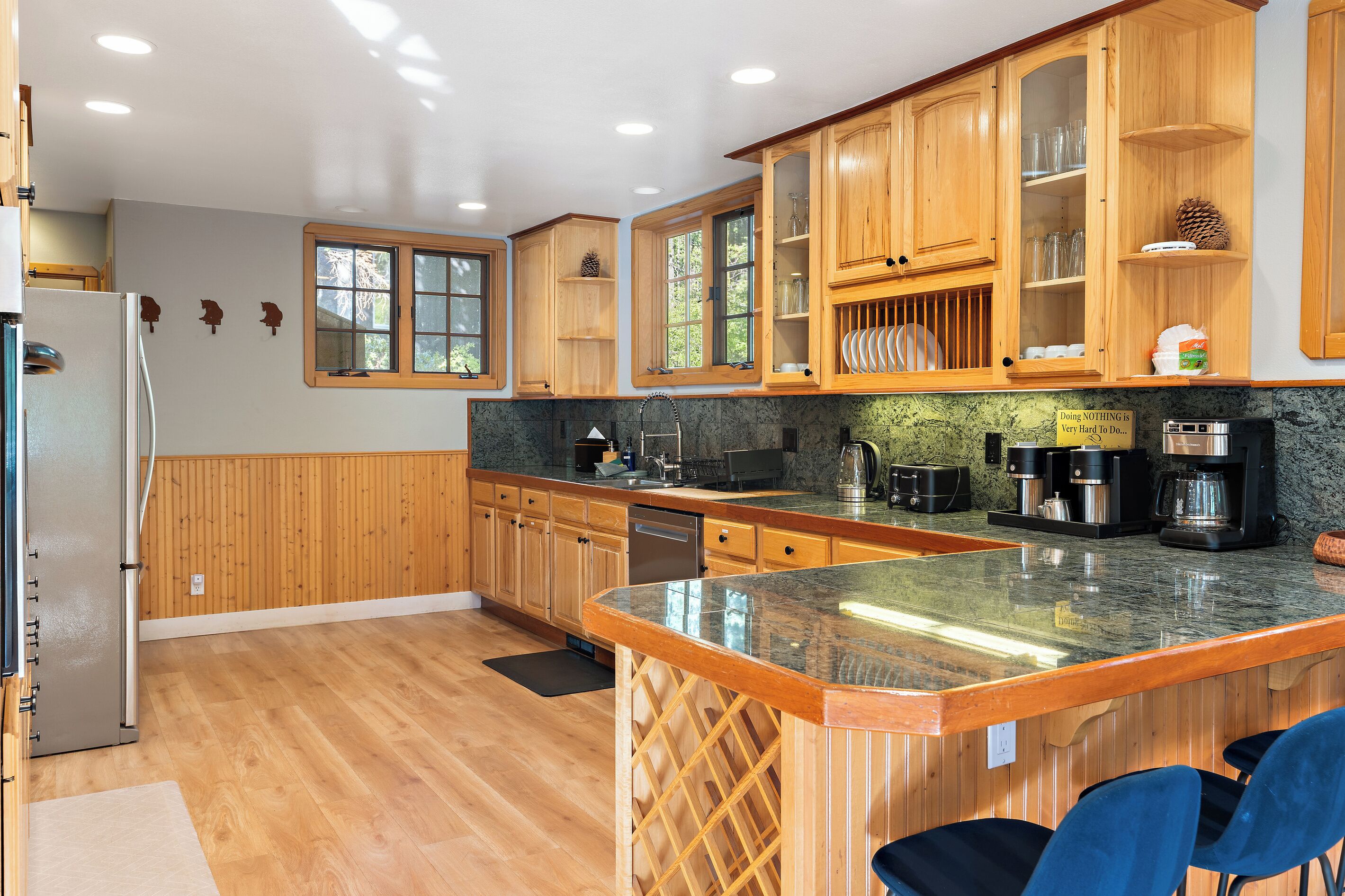 A kitchen with wooden cabinets, a granite countertop, and a built-in wine rack.