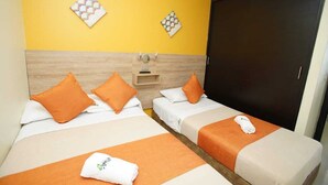 Ein Hotelzimmer mit zwei Betten, jeweils mit orangefarbener Bettwäsche und Kissen, einem Holz-Kopfteil und einem dunkelbraunen Kleiderschrank.