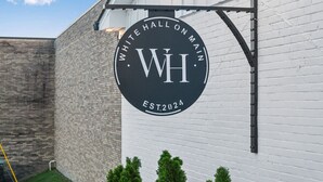 A circular sign with "WH" and "EST. 2024" on a white brick wall. - North Nashville 15mins to Broadway Luxury Listing (Goodlettsville)