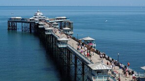 A pier extending into the water with multiple levels, a covered walkway, and a view of the sea. - Cosy Studio Central Colwyn Bay (Colwyn Bay)