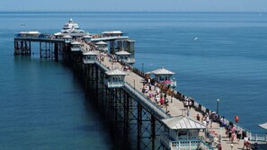 A pier with multiple levels, extending into the water, with people walking along it.