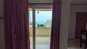 Een kamer met een schuifglazen deur naar een balkon.