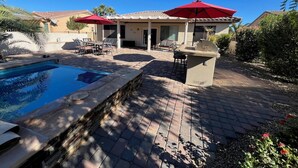 A backyard with a swimming pool, patio furniture, and a barbecue area. - Entertainment Friendly Home in “The Grand” - Surprise, AZ! (Surprise)