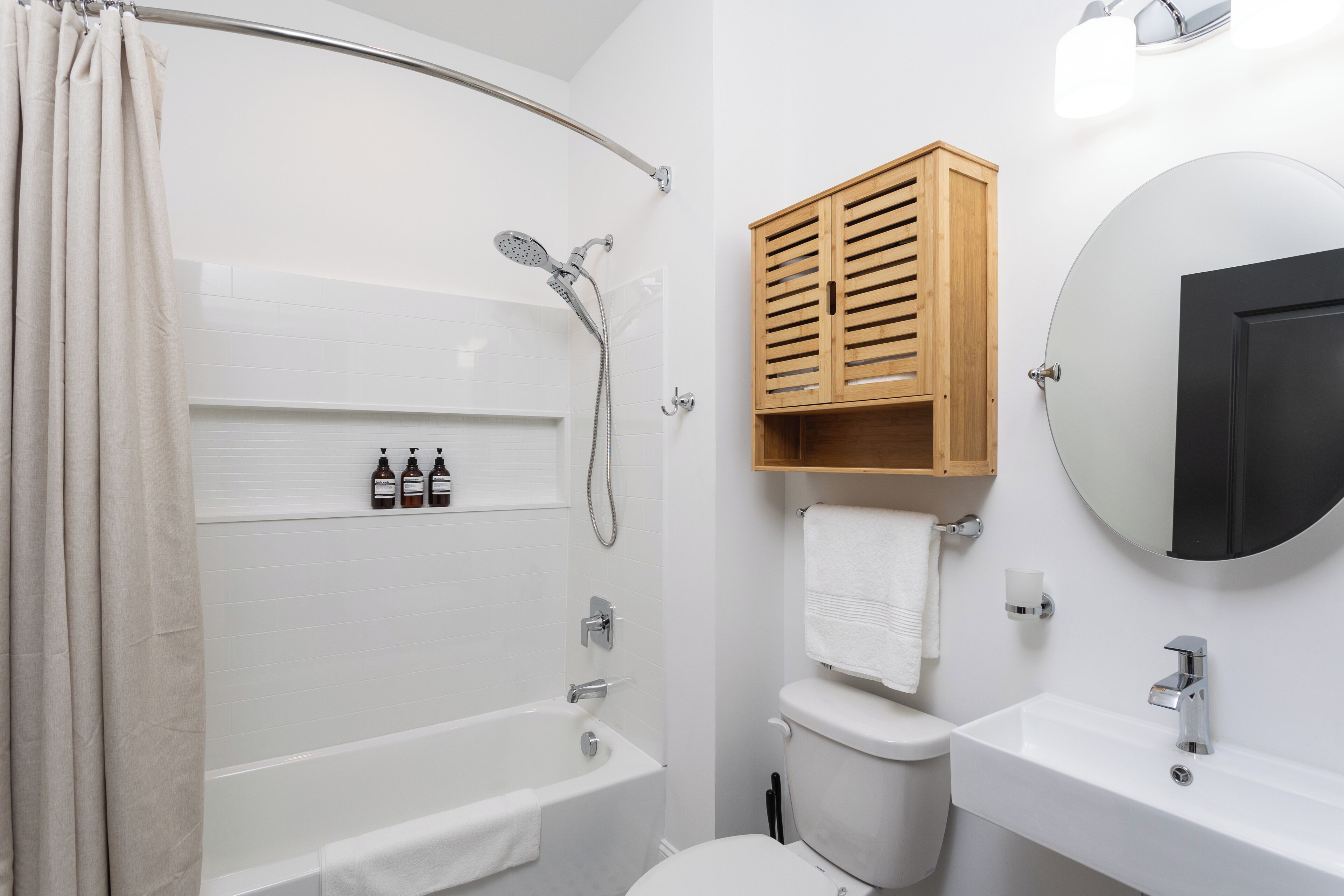 A modern bathroom with a bathtub, toilet, and sink.