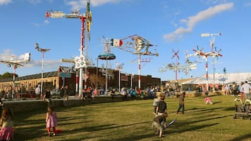 Een park met diverse attracties en een gebouw op de achtergrond.