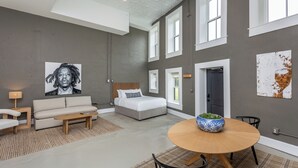 A modern living room with a sofa, coffee table, and a dining table with a bowl. - The Harriss (Wilson)
